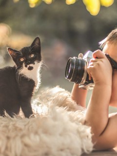 Мальчик, фотографирующий котёнка