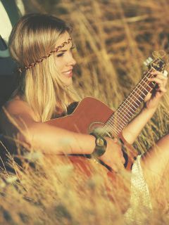 Блондинка – хиппи с гитарой
