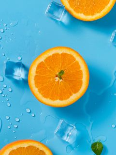 Апельсины и мокрый лёд на голубом фоне