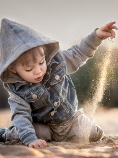 Мальчик, играющий с песком