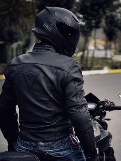 Мотоциклист в кожаной куртке и шлеме