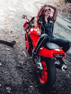 Девушка в кожаном комбинезоне на мотоцикле