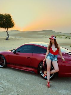 Девушка у авто в пустыне на закате