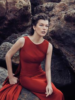 Милла Йовович в красном платье на камнях