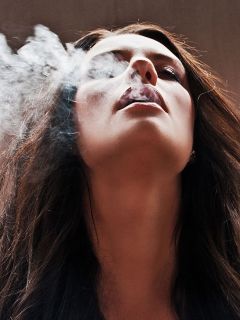 Девушка, пускающая сигаретный дым