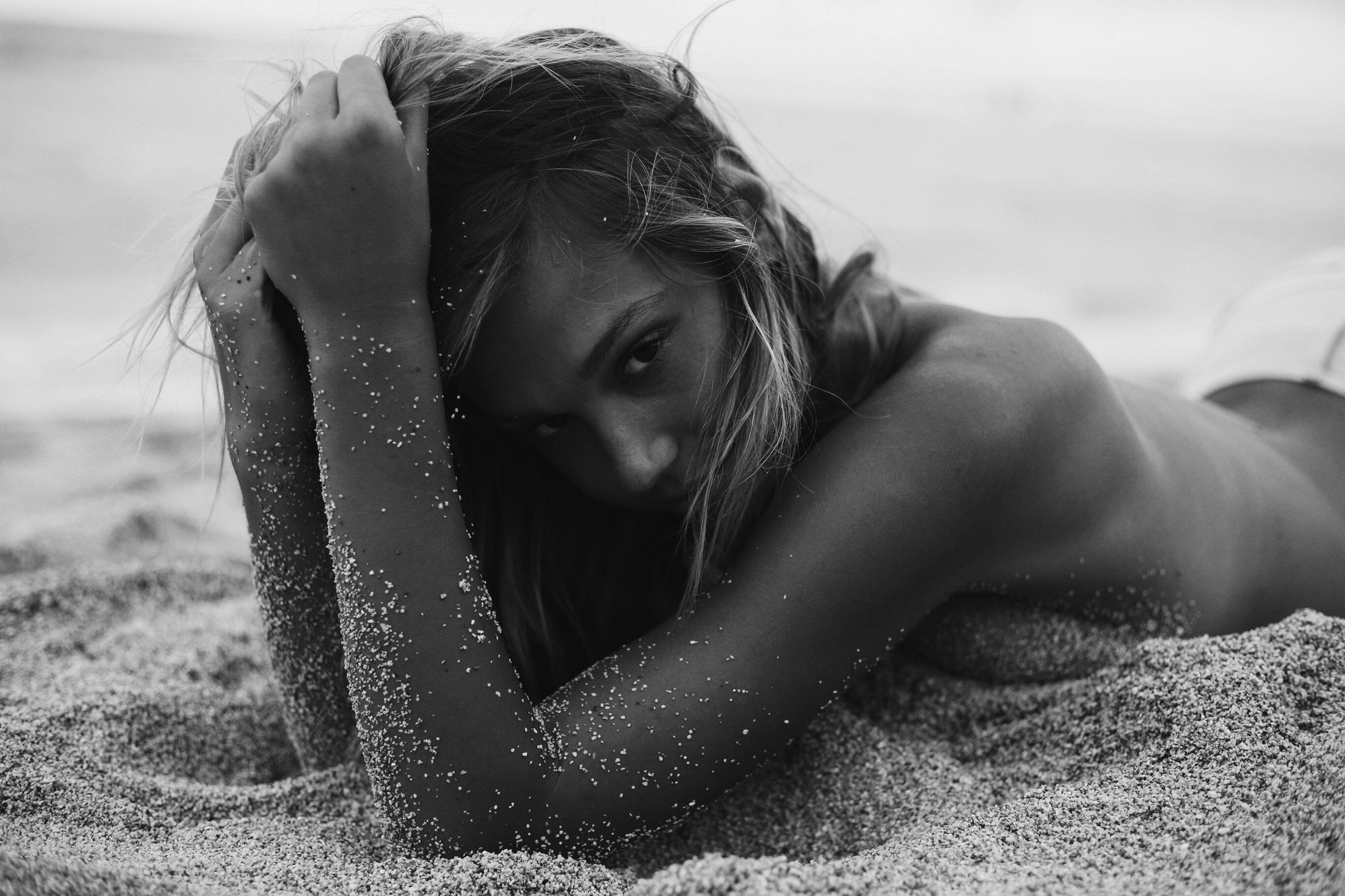 Лежащая девушка в песке