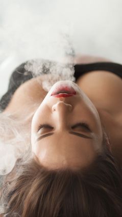 Девушка, выпускающая дым